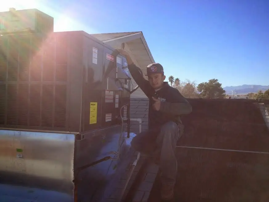 HVAC technician performing Heat Pump Repair on a rooftop unit in Stewartville