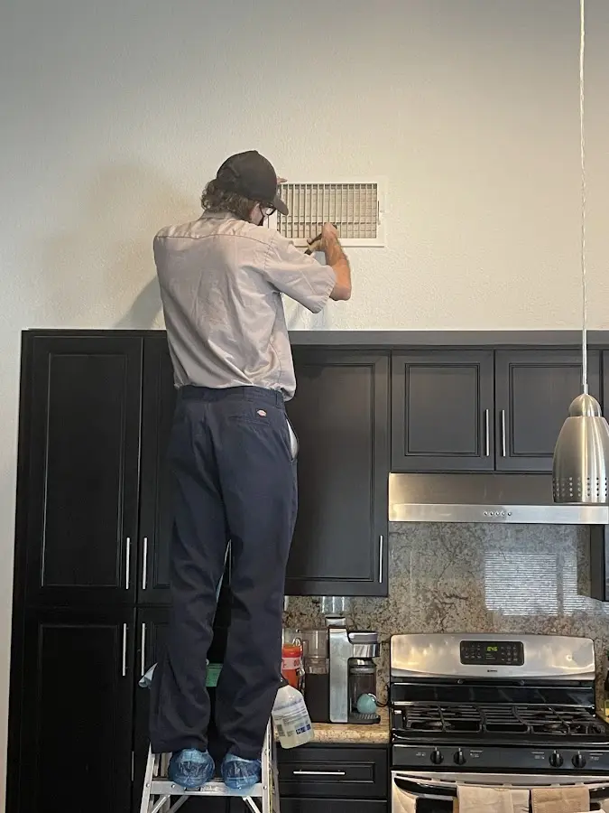 Technician inspecting an air vent during HVAC service in Stewartville